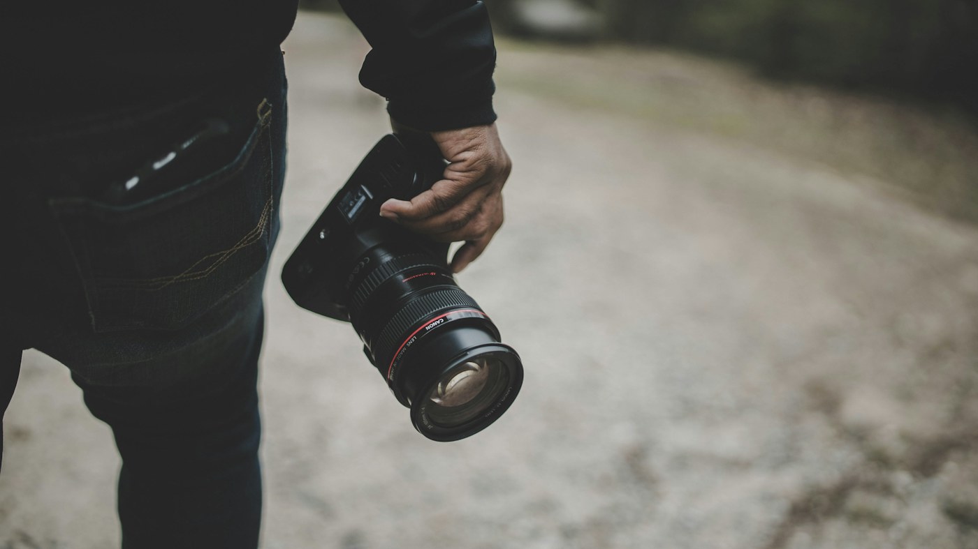 A photographer holding a camera, ready for a shoot.
